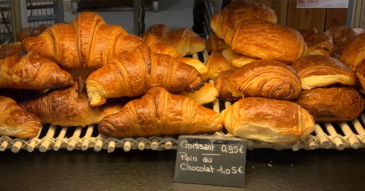 Croissants et pains au chocolat rangés dans la vitrine d'une boulangerie