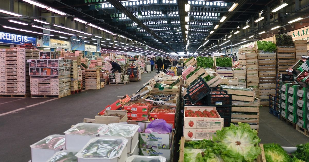 Halle de marché de gros, palettes et cageots de fruits et légumes en enfilade